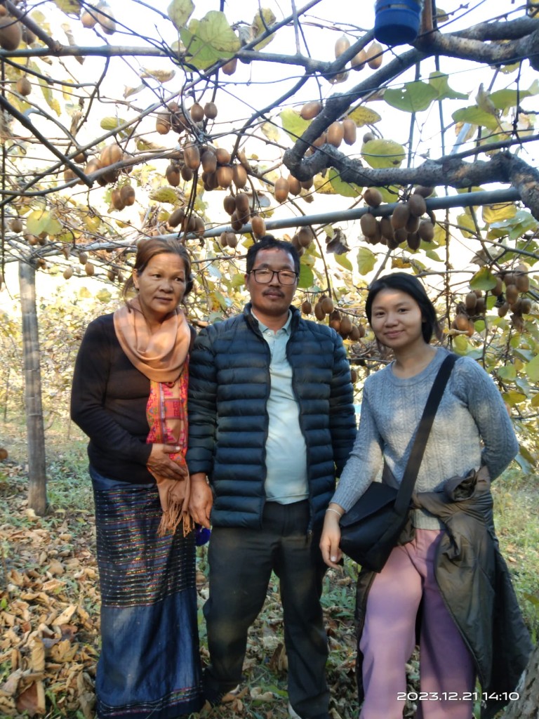Visitors in a kiwi orchard in Anjaw