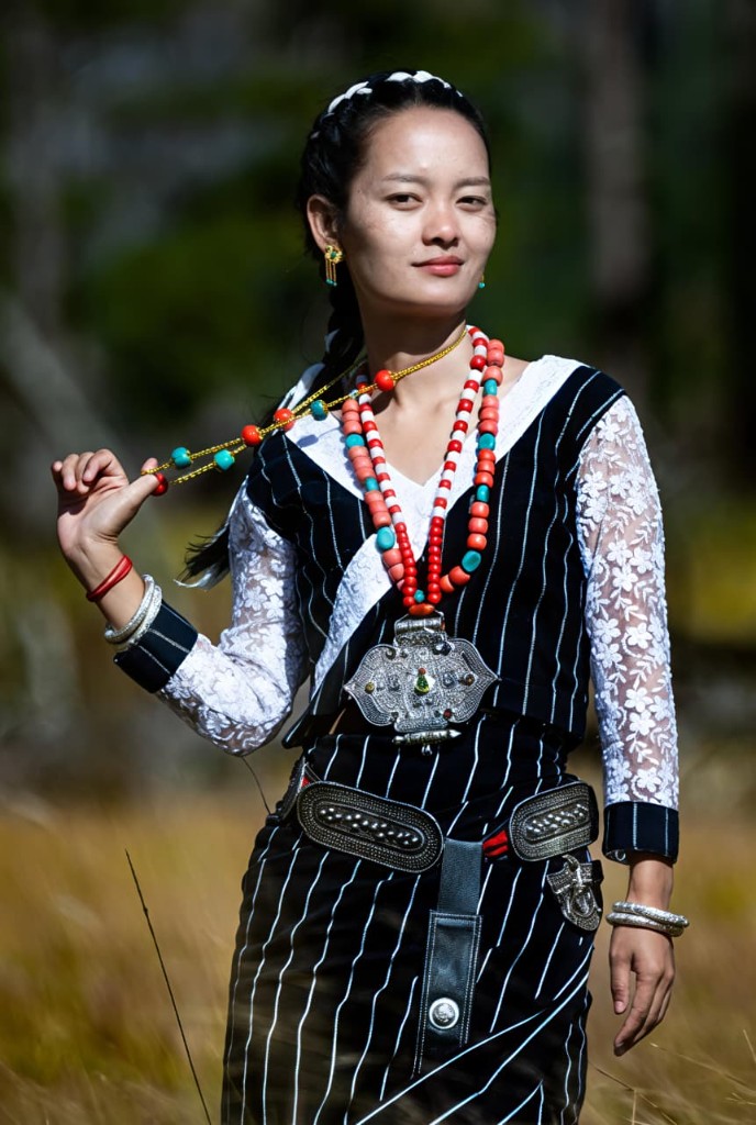 A community member in traditional attire with vibrant beads.